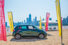 fiat car on sand next to the water