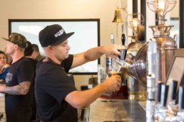 man pouring beer from a tapper
