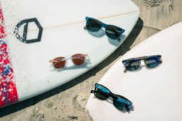 four sunglasses on surfboards