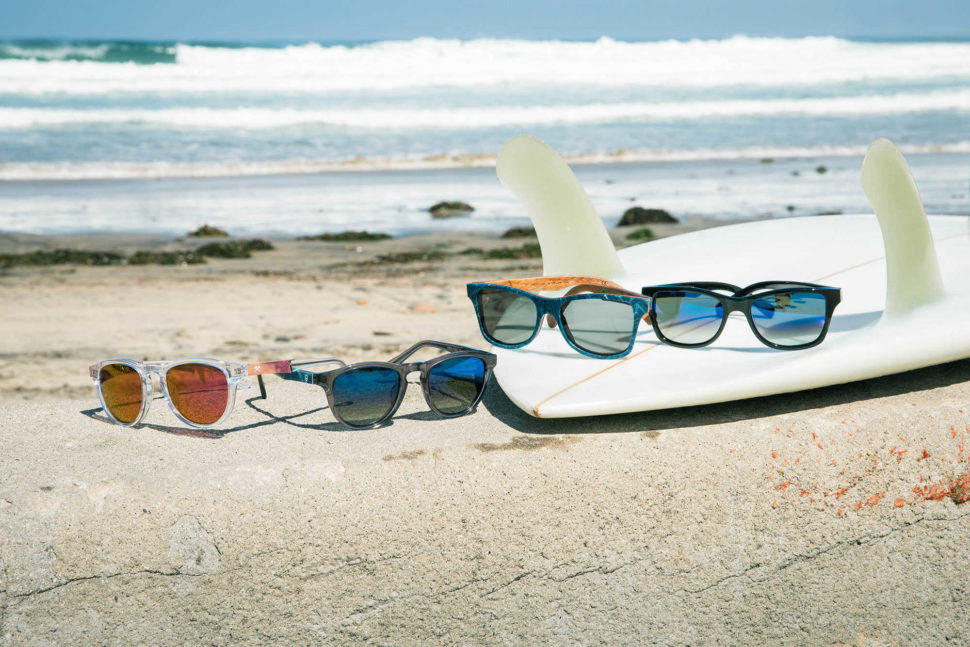 glasses on top of surfboard next to waves
